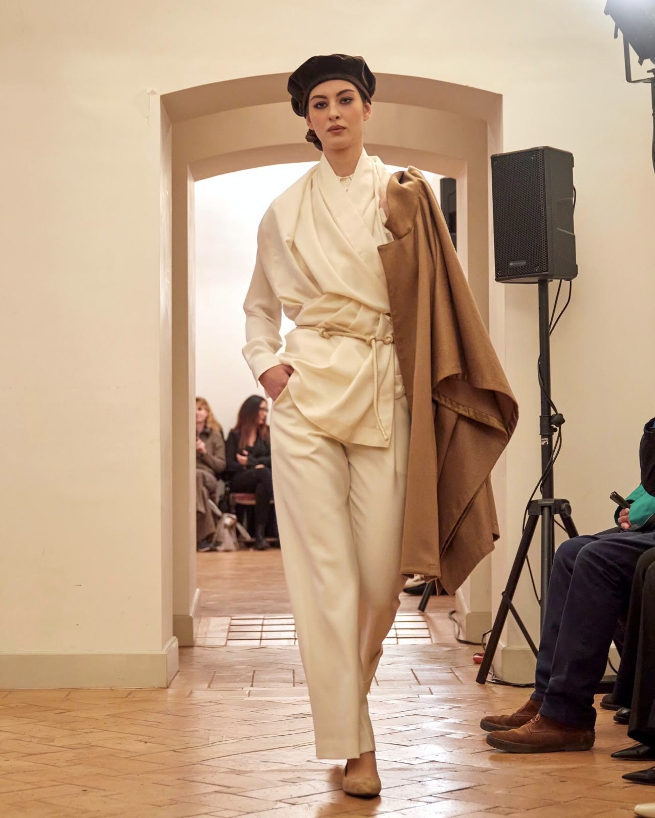 modella con completo bianco e mantella cammello